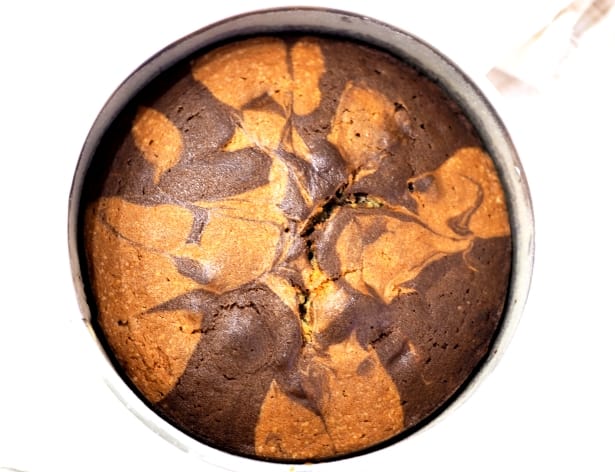 A baked round marble cake in a cake tin