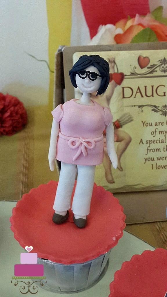 A cupcake with a lady figurine topper