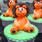Green cupcakes with orange and brown lion toppers.