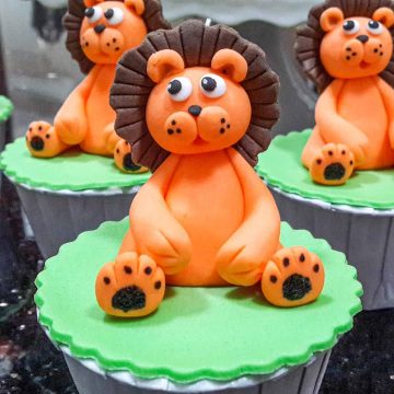 Green cupcakes with orange and brown lion toppers.