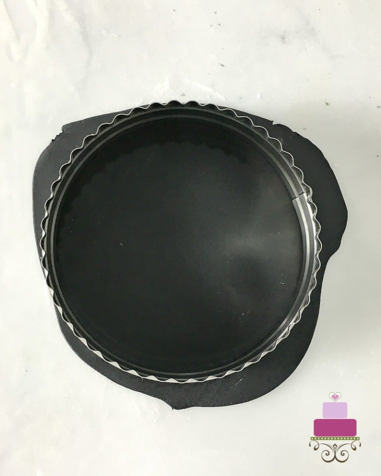 Cutting a round fondant piece with a round cutter