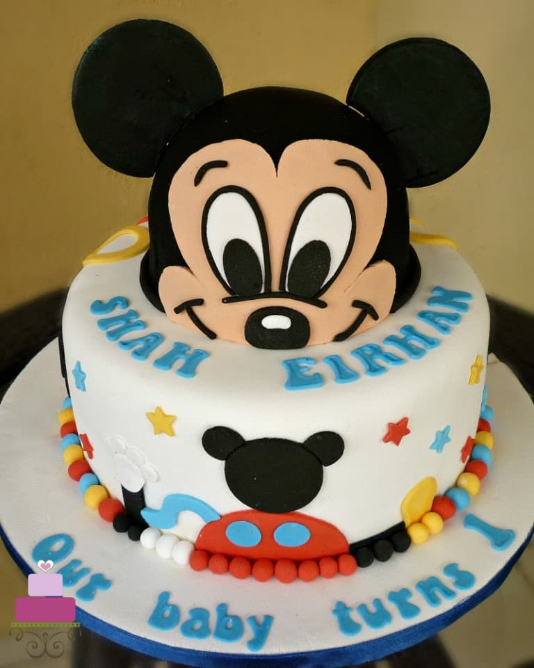 A round cake with 3D Mickey face as the top tier