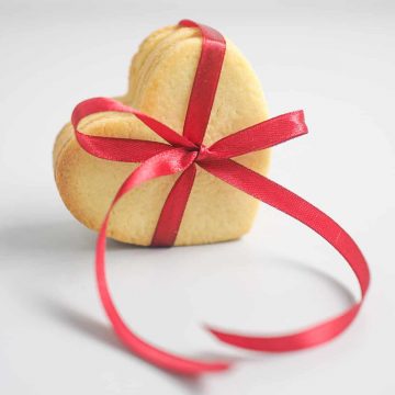 A group of heart shaped cookies tied together with a red ribbon