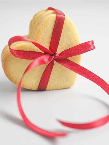 A group of heart shaped cookies tied together with a red ribbon.