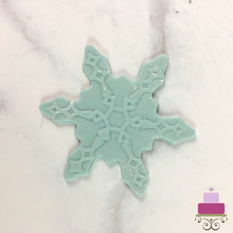 A blue snowflake fondant cutout.
