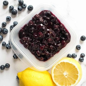 Blueberry pie filling in a square container, with lemon and fresh blueberries on the side