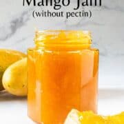 A jar of mango jam with the lid open.
