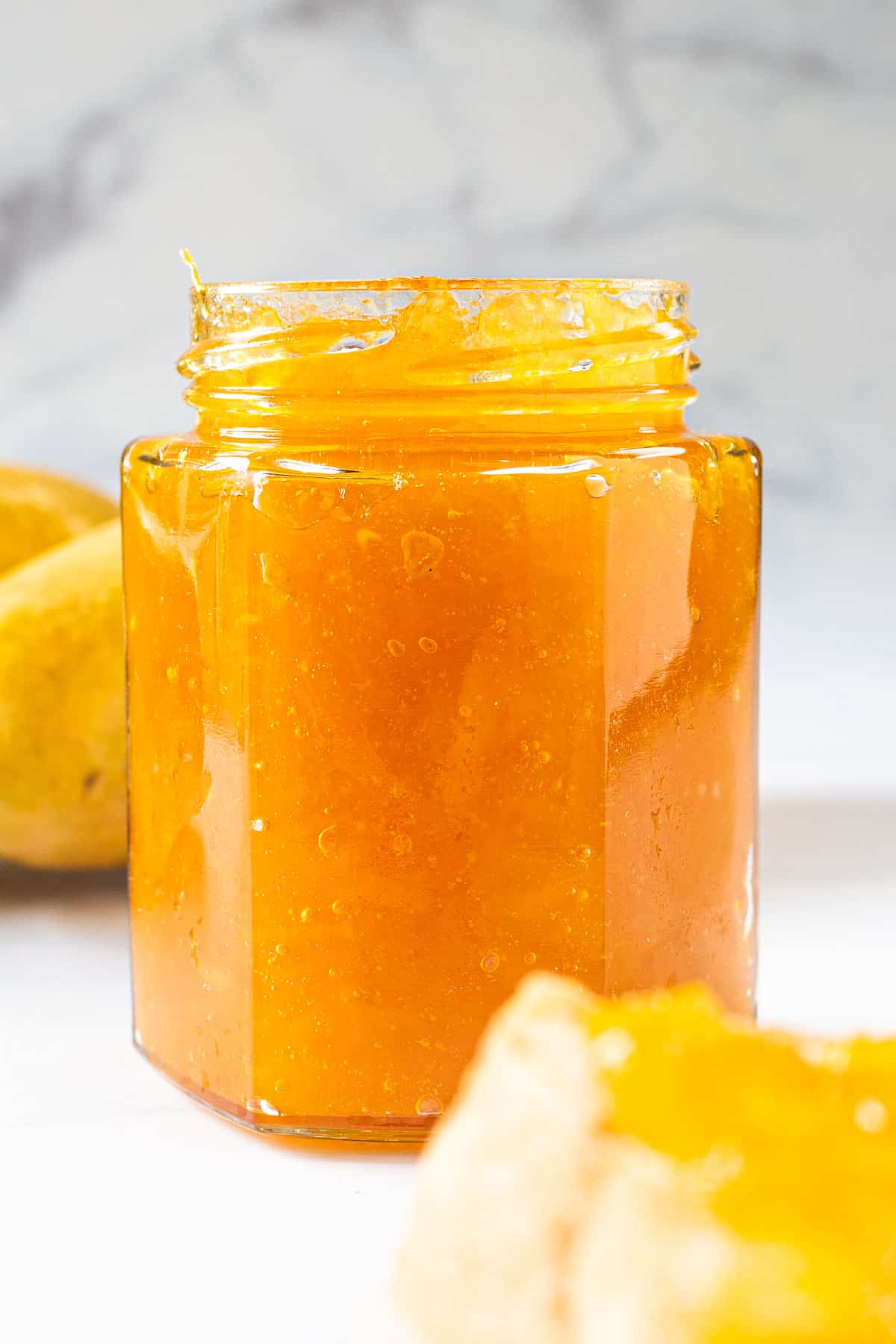 A jar of mango jam with the lid open