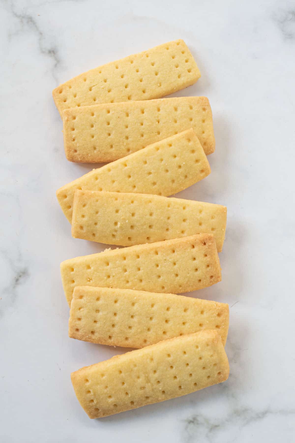 Shortbread cookies recipe - A row of rectangle shaped shortbread cookies against a marble background.