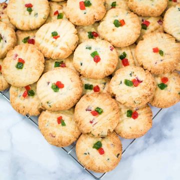 A wire rack topped with round cherry cookies