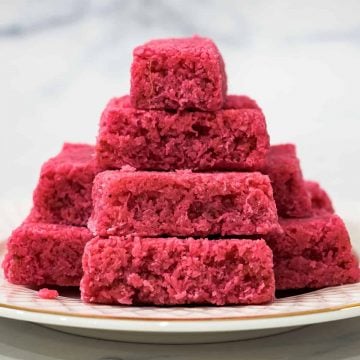 Pink bars of coconut candy stacked on a plate
