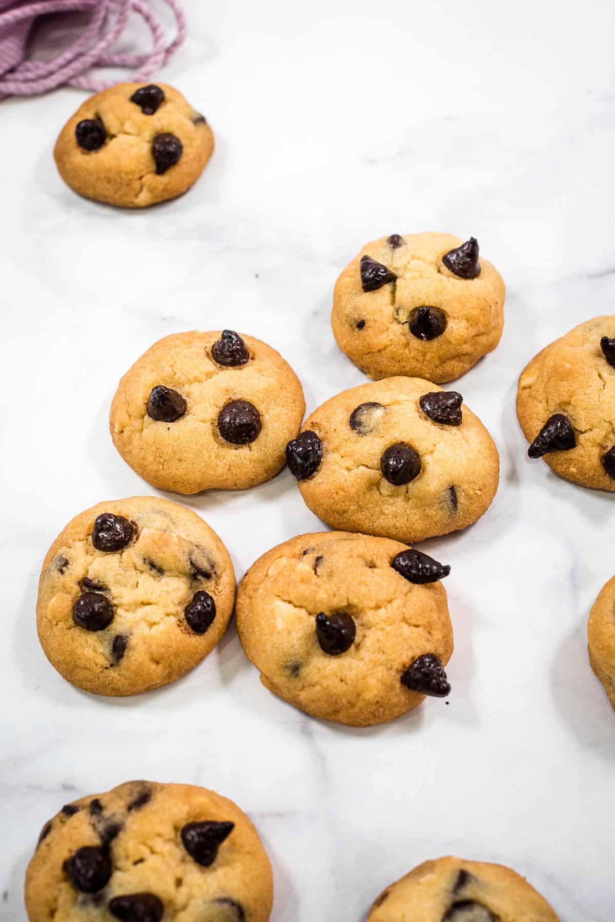 Close up of mini chocolate chip cookies against a marble background
