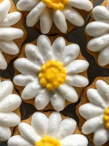 Sugar cookies decorated with royal icing piped daisies