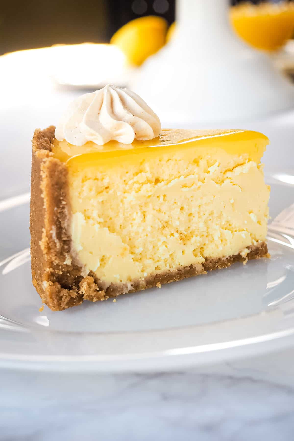A slice of lemon curd cheesecake on a white plate.