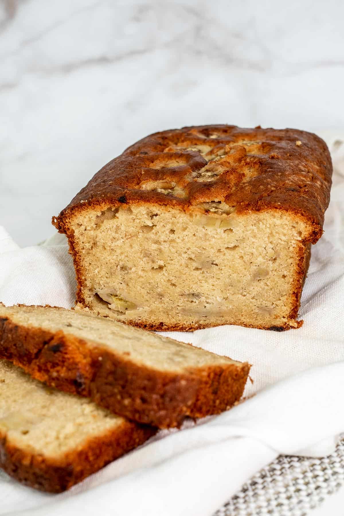 A loaf of banana pound cake with some slice cut