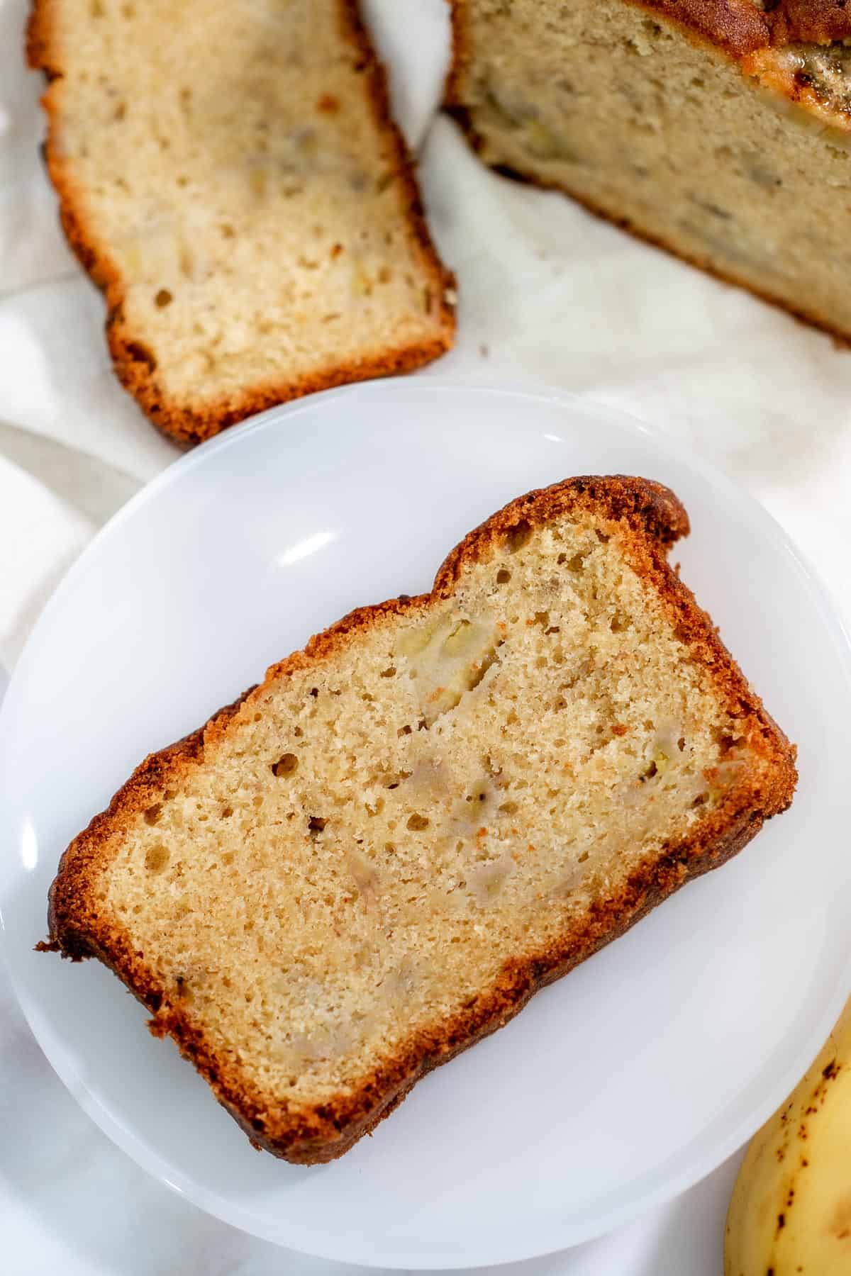 A slice of loaf cake on a white plate.