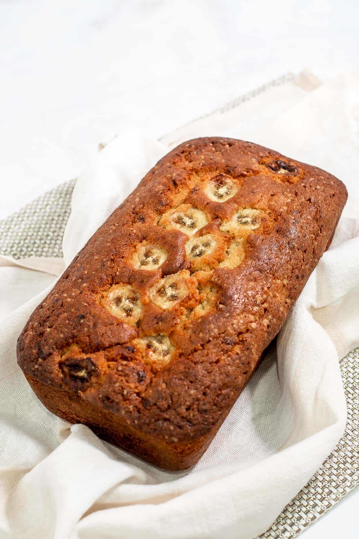 A loaf of cake baked with banana slices on top.