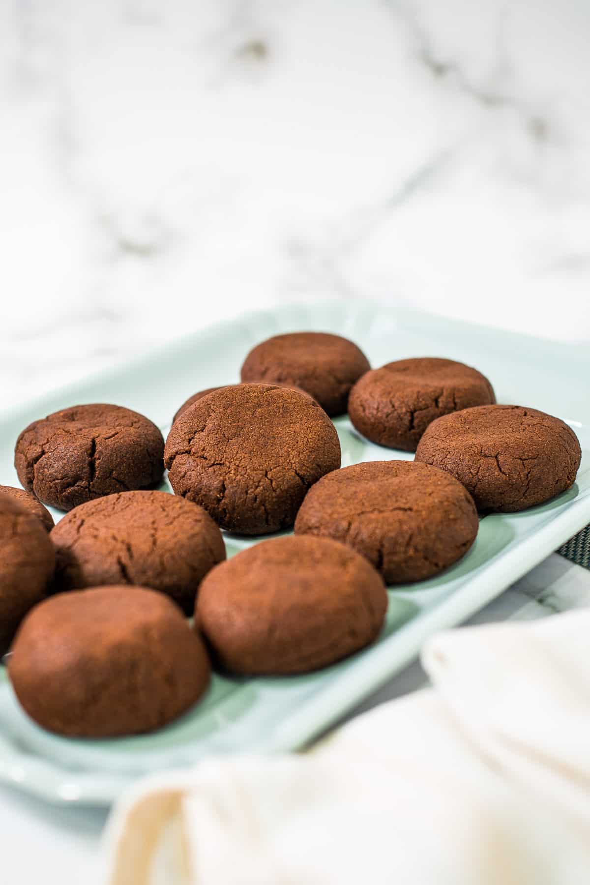 A green tray of round chocolate cookies.