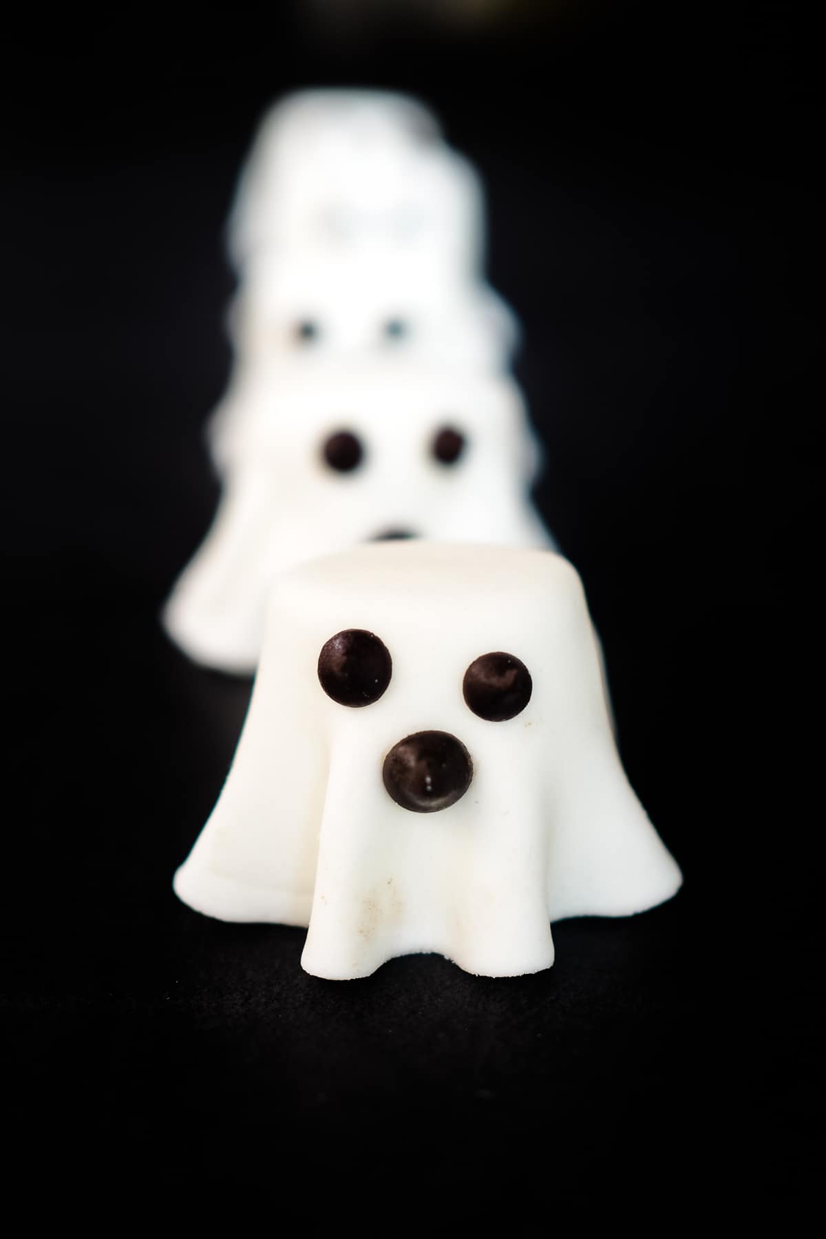 Marshmallow ghosts made of fondant and marshmallow and chocolate chips