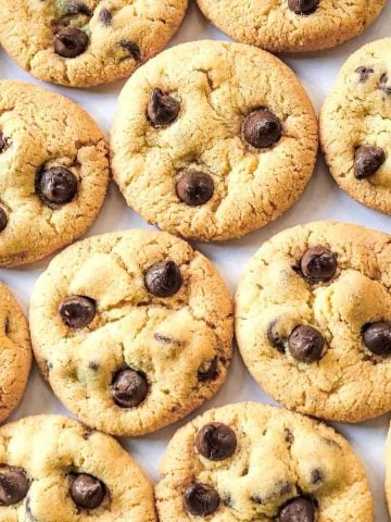 Chocolate chip cookies arranged flat, close to one another.