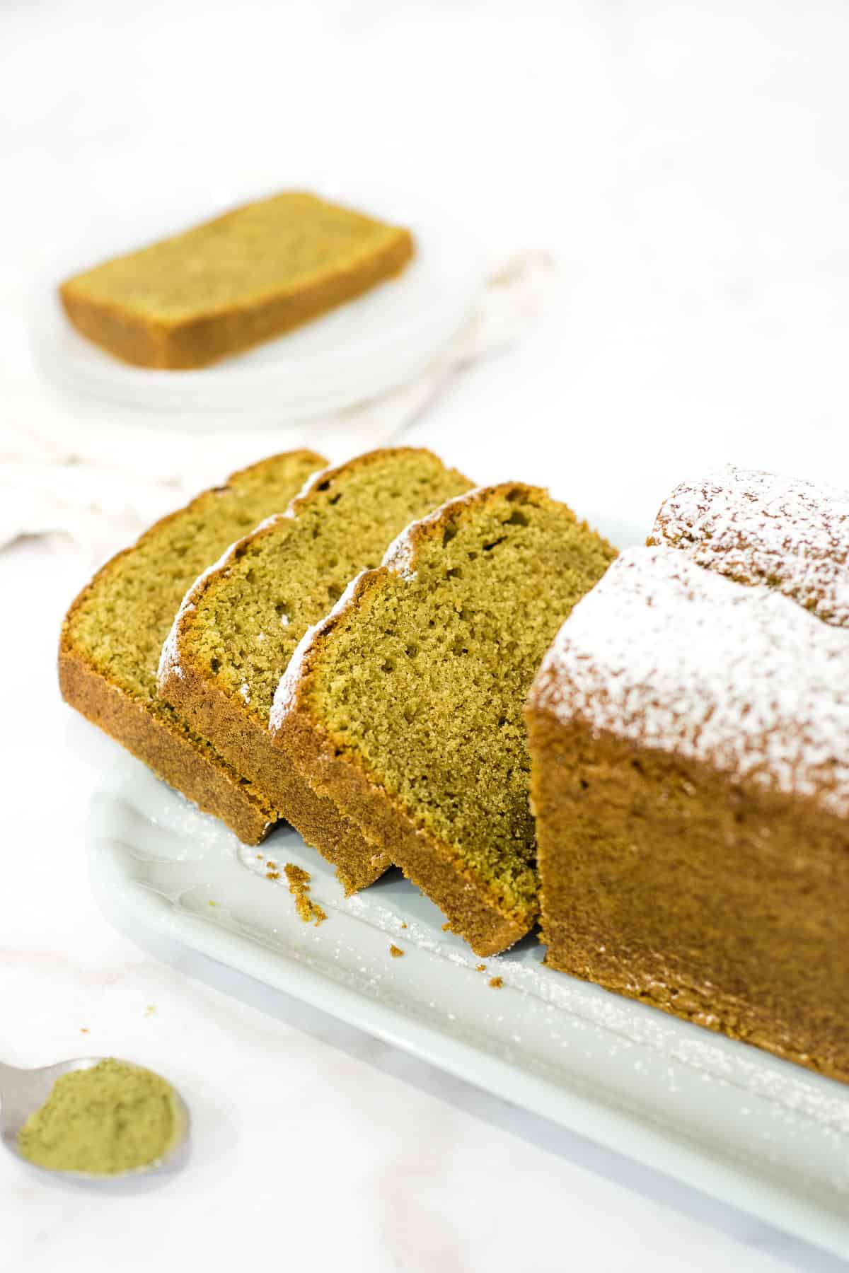 A loaf of matcha pound cake cut into slices