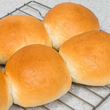 Baked buns on a wire rack.