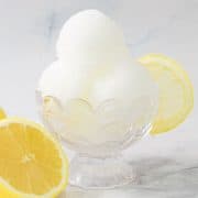 Lemonade sorbet in a dessert cup, with lemon on the side