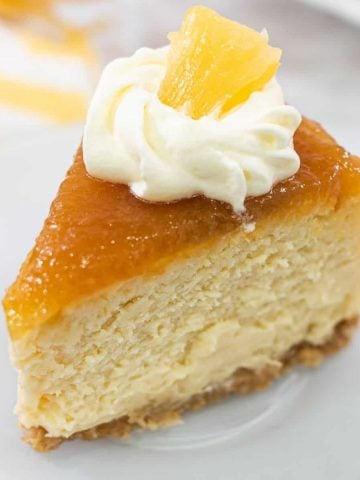 A slice of cheesecake with pineapple topping and whipped cream