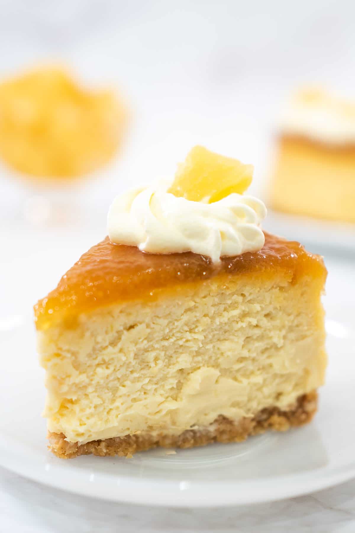 A slice of cheesecake with pineapple topping and whipped cream