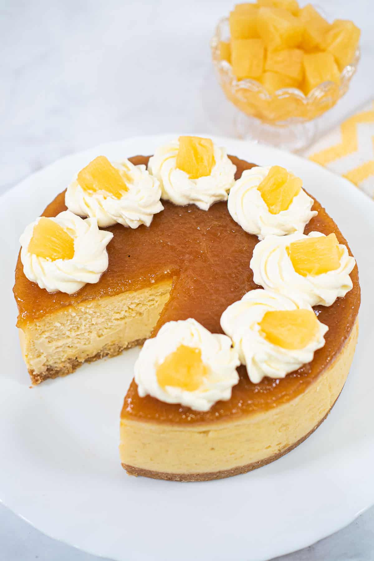 A pineapple cheesecake with a slice cut out