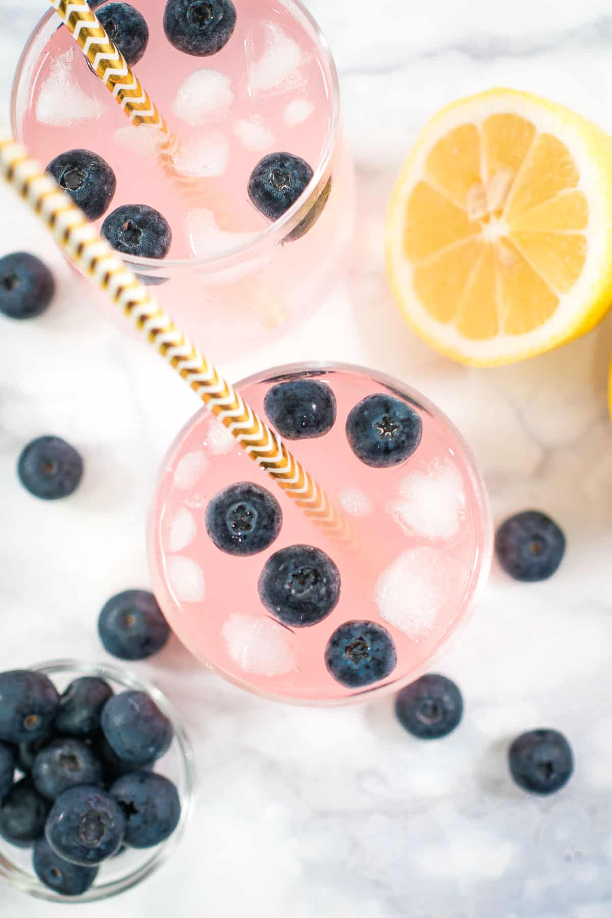 Top view of pink lemonade with blueberries in a glass.