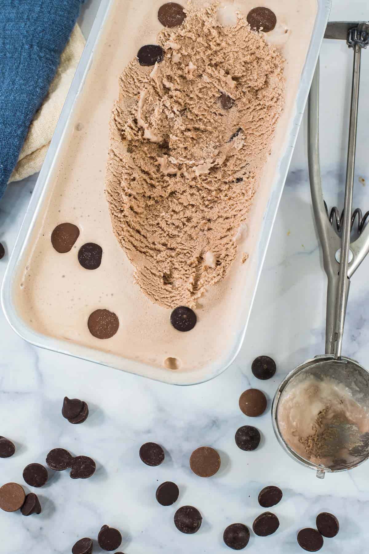 A tray of ice cream with an ice cream scoop at the side
