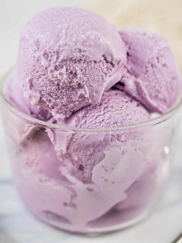 Scoops of purple ice cream in a transparent glass