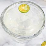 A bowl of clear jelly and a half sliced lime.