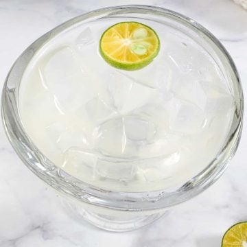A bowl of clear jelly and a half sliced lime