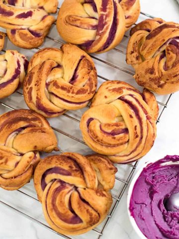 Twisted ube rolls on a wire rack