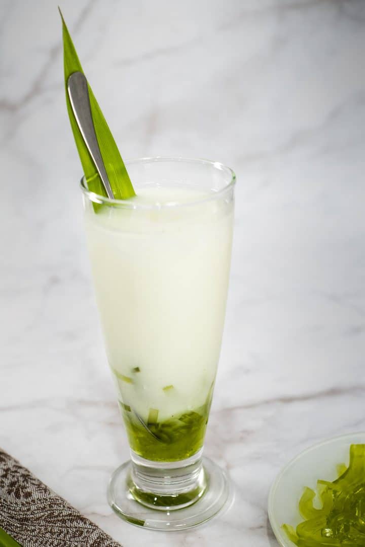 A tall glass of milk with green jelly boba strips