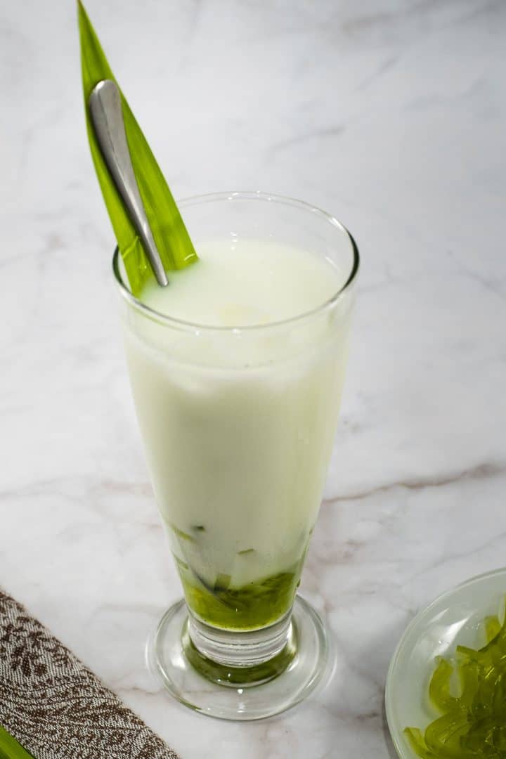 A glass of pandan milk with pandan jelly strips