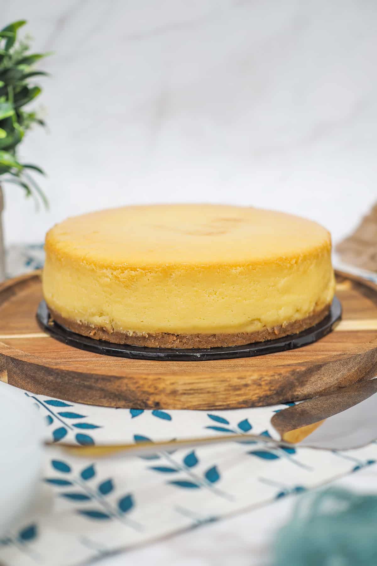 A round durian cheesecake on a wooden tray.