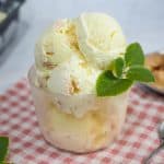 Lychee ice cream scoops in a glass bowl and decorated with mint leaves.