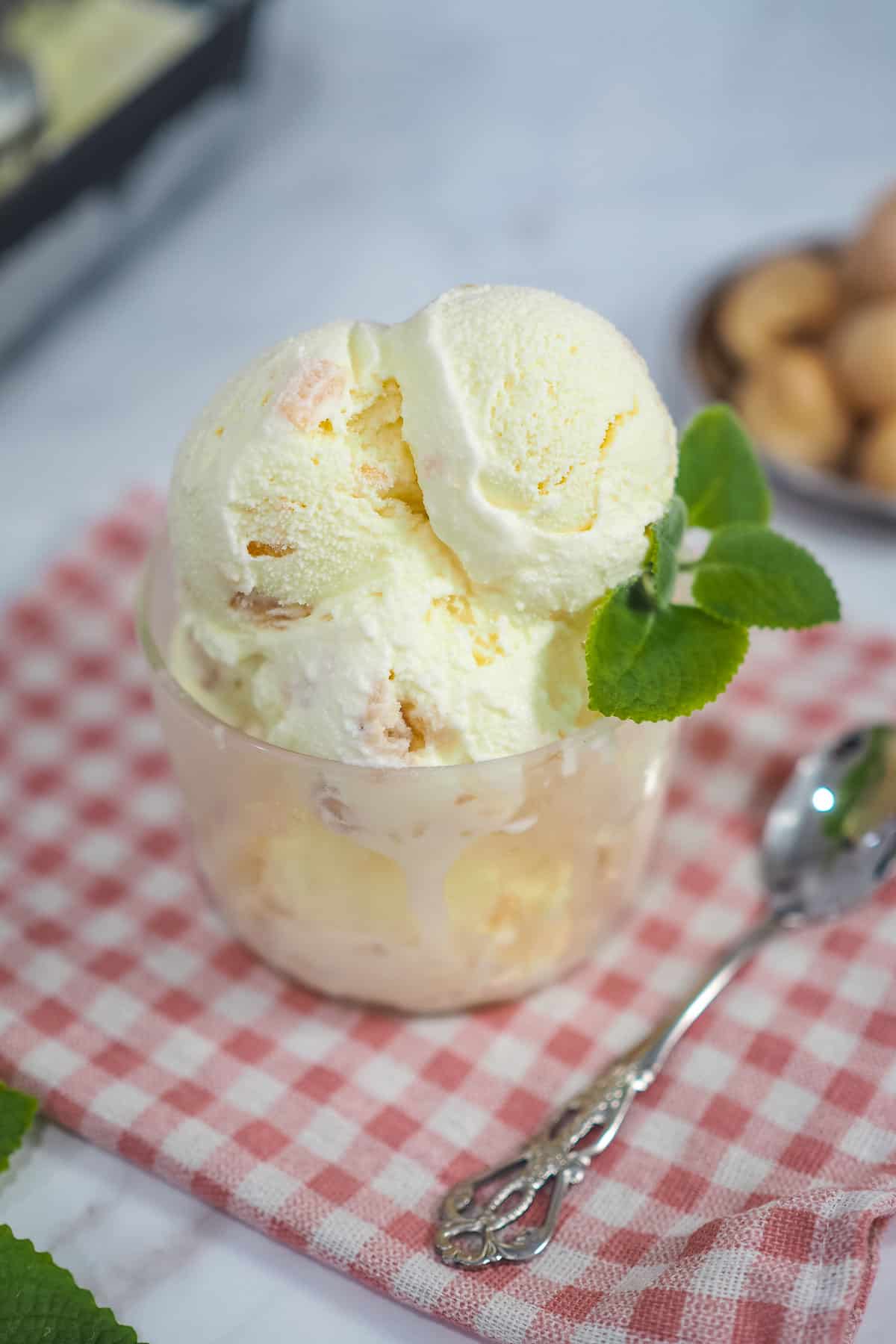 Ice cream scoops in a glass bowl and decorated with mint leaves.