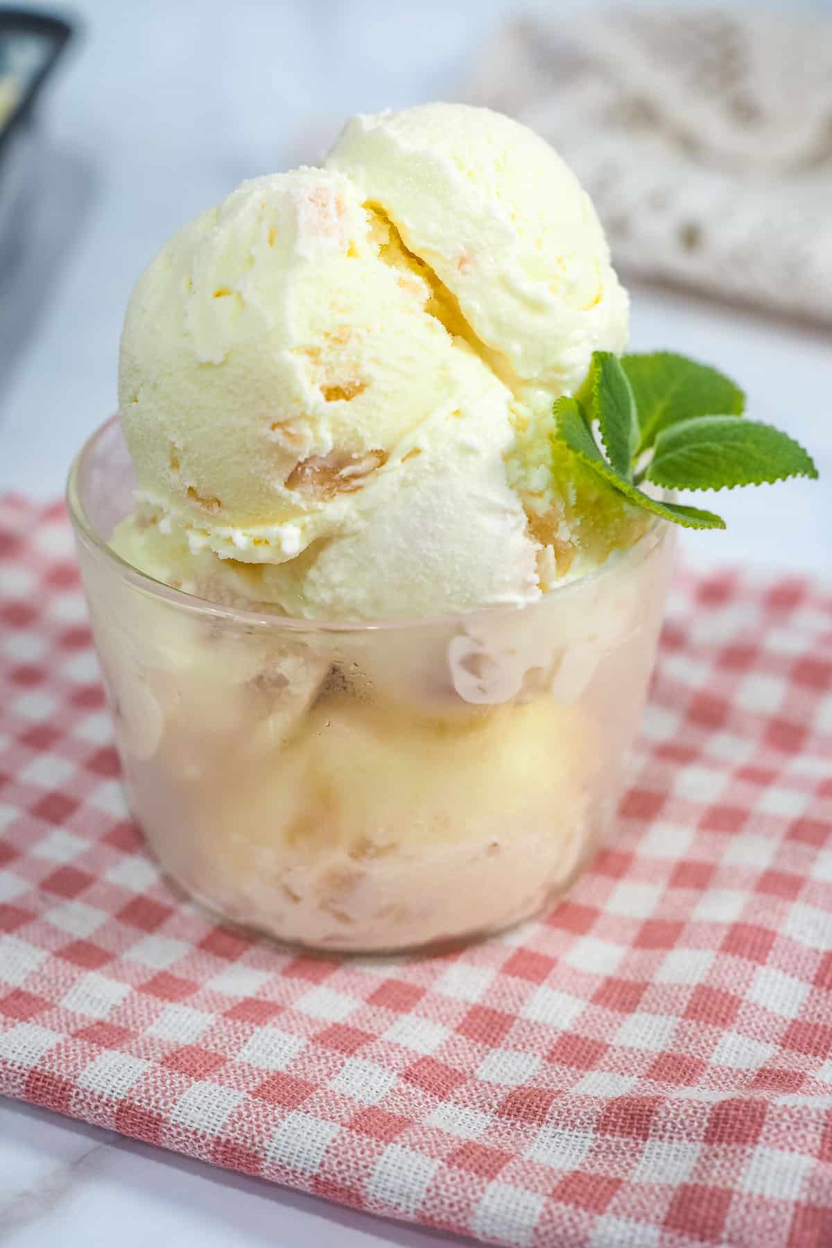 Lychee ice cream scoops in a glass bowl and decorated with mint leaves.