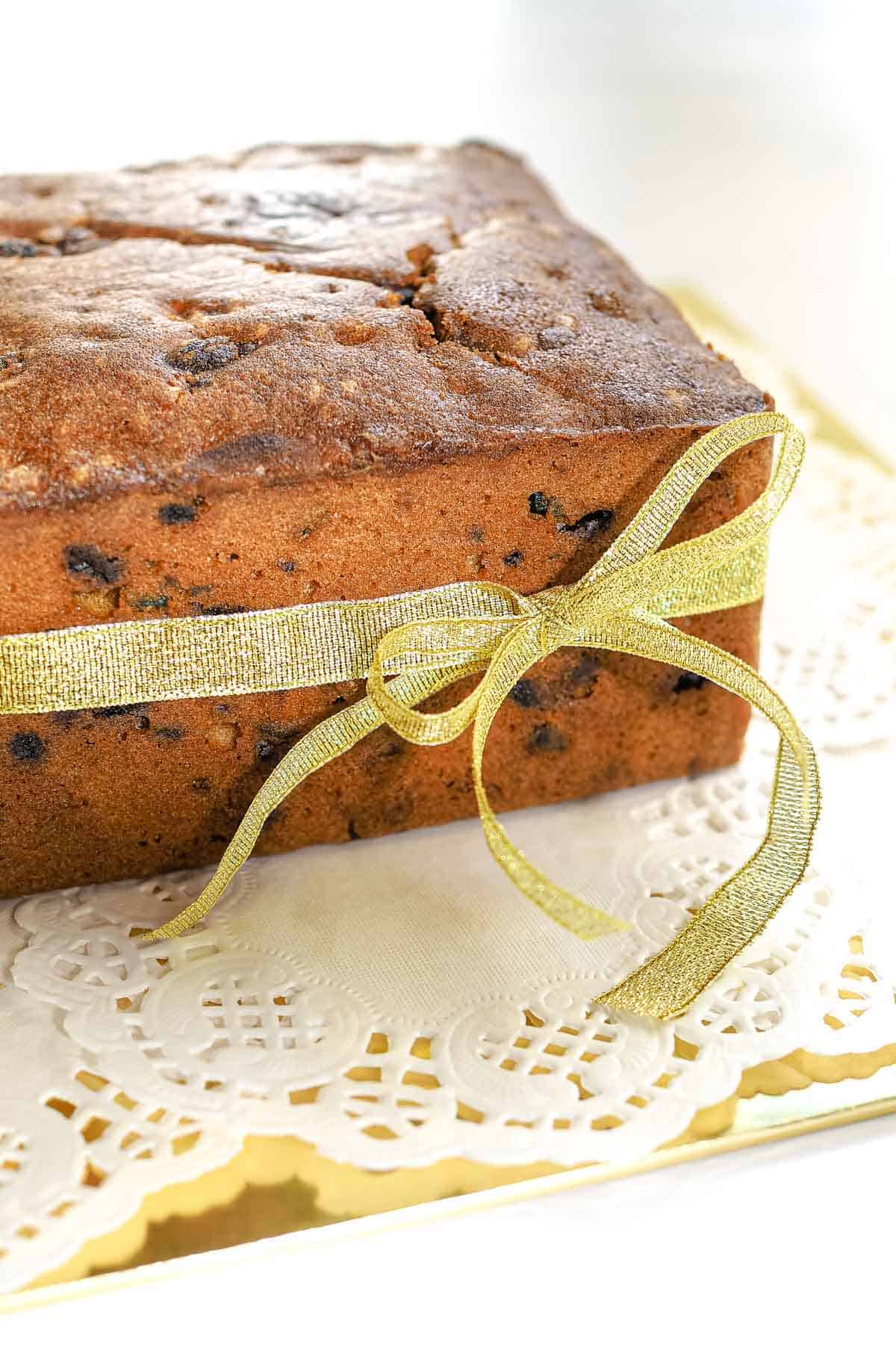 A tall fruit cake baked in a deep cake pan.