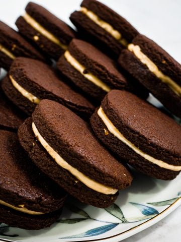 Chocolate peanut butter sandwich cookies in a plate.
