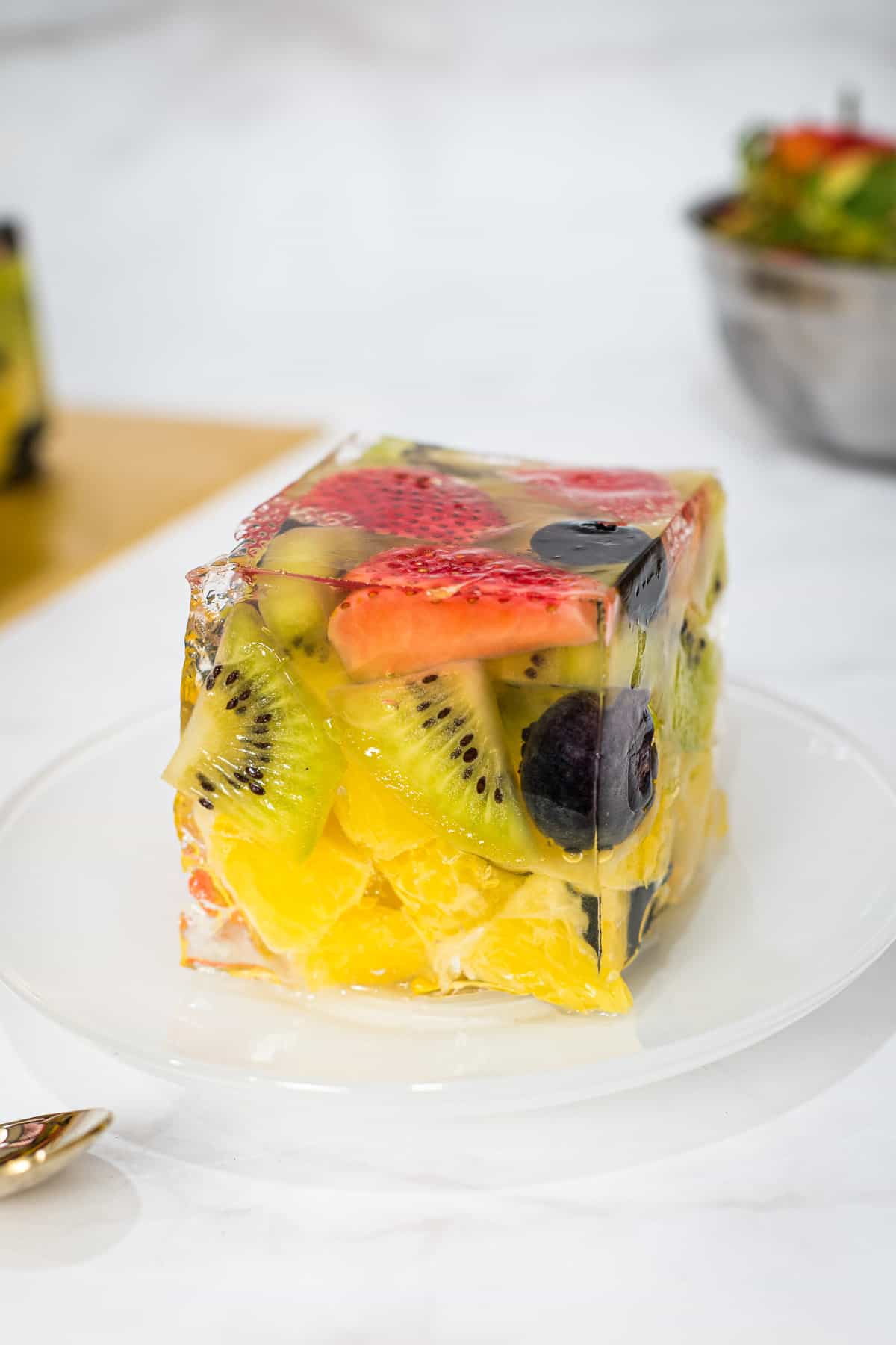 A slice of fruit jelly cake on a white plate.