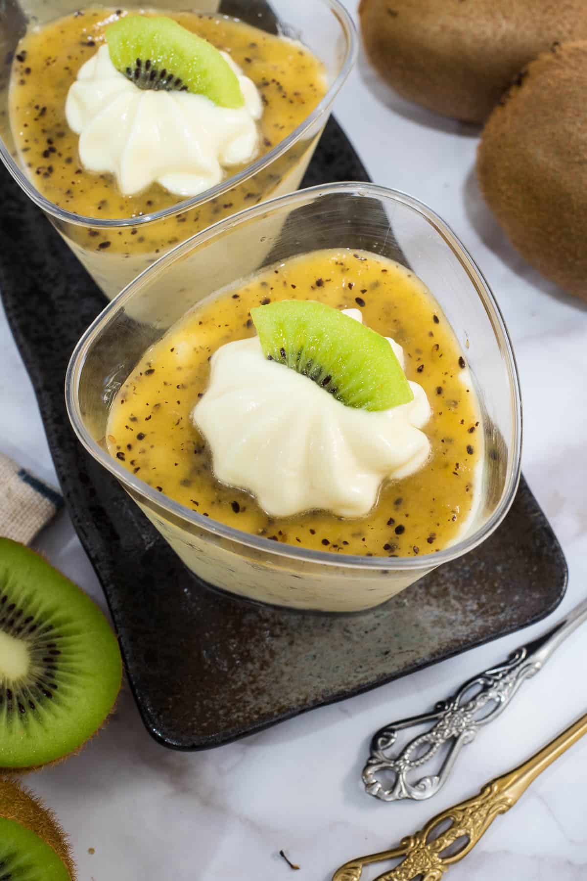 Top view of a cup of mousse with a slice of kiwi on top.