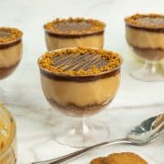 4 Lotus Biscoff pudding cups with a spoon on the side and 2 cookies.