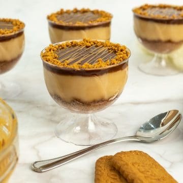 4 Lotus Biscoff pudding cups with a spoon on the side and 2 cookies.