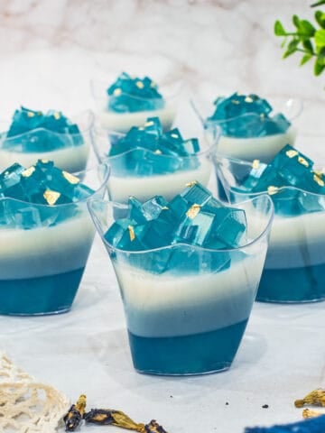 7 cups and blue and white layered jelly.