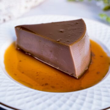 A slice of ube flan on a white plate.